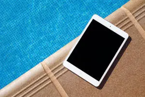 A Sleek Silver iPad Displayed on a Minimalistic Gray Desktop